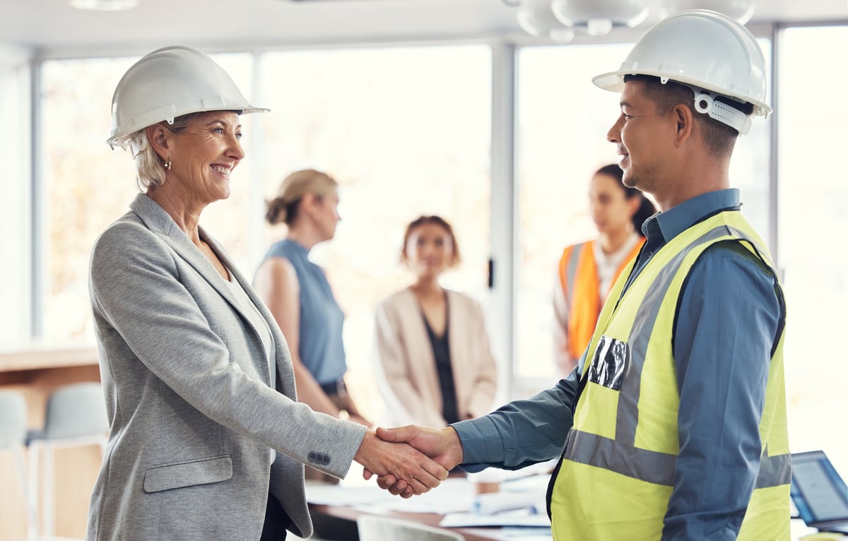 Realtor and contractor reviewing documents together, partnership in real estate